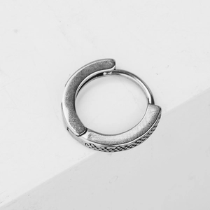 Minimalist silver steel hoop earring with vintage embossed texture in a 45-degree angle