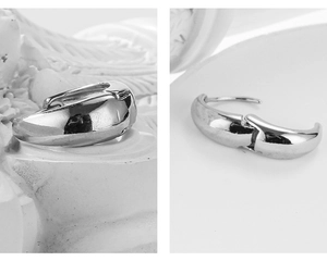 Detailed close-up of chunky silver crescent earrings with a high-polished mirror finish