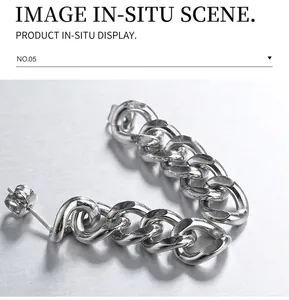 Detailed close-up of silver Cuban link chain earrings on a black stone background
