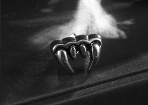 Dettaglio ravvicinato di orecchino a perno a zanna di vampiro in acciaio inossidabile