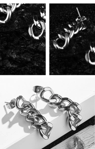 Macro detail of silver stainless steel chain link earrings with polished finish