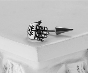 Macro detail of retro steel Hamsa Hand earring with Evil Eye relief on stone base
