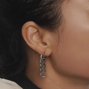 Sleek stainless steel Cuban link chain drop earrings shown on a female model