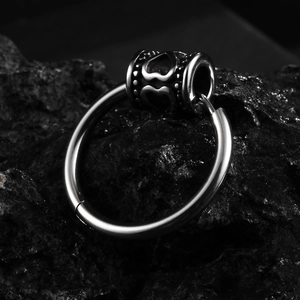 Polished stainless steel hoop earring with engraved heart bead on volcanic rock
