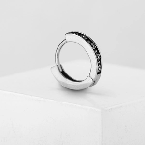 Silver stainless steel huggie earring with black sun pattern engraving on white stand