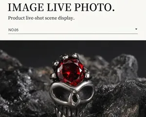 Macro shot of Gothic skull ring in aged steel with a faceted red gemstone set on top