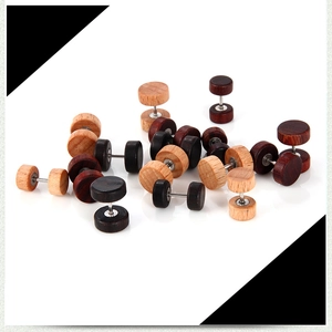 Détail macro de boucles d'oreilles haltères en bois naturel aux tons brun et ébène