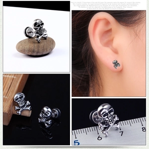 Vue détaillée des boucles d'oreilles tête de mort avec mesure et essai de porté