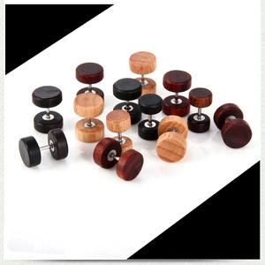 Détail macro de divers clous d'oreilles ronds en bois style haltère en tons variés