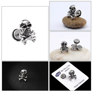 Vue macro des boucles d'oreilles punk crâne en acier argenté sur carte de présentation