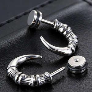 Macro shot of silver punk dragon claw earring with screw-on flat back and black rubber ring