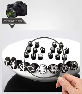 Macro view of stainless steel barbell earrings featuring assorted geometric patterns