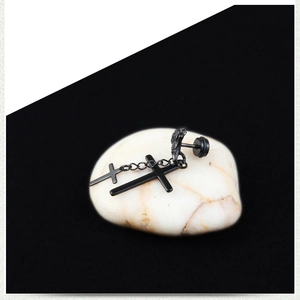 Détail macro d'un clou d'oreille main squelette punk avec pendentifs croix noirs sur pierres