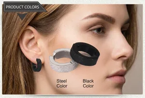 Detail view of steel and black matte clip-on earrings with sandblasted finish texture