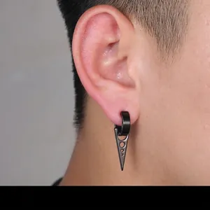 Detail of a minimalist black triangle ear clip for non-pierced ears on a male model