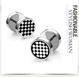 Détails macro des boucles d'oreilles barbell en acier avec motif damier noir et blanc chic