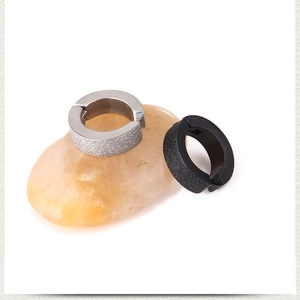Detail of matte silver and black titanium steel clip-on earrings with sandblasted finish