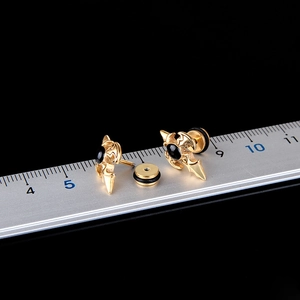 Gothic gold titanium steel cross stud earrings with black gemstone in macro view