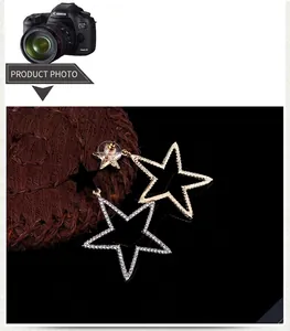 Detailed view of asymmetrical star earrings with rhinestones and textured gold finish