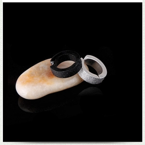 Macro detail of matte titanium steel non-pierced clip earrings in black and silver finishes