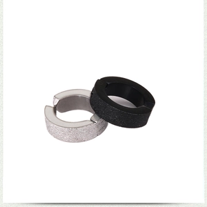 Detail of matte silver and black spring-clip earrings with frosted sand surface texture