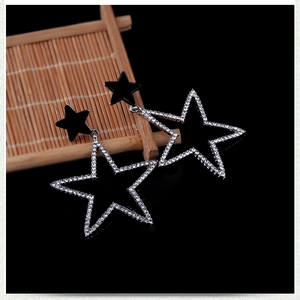 Detailed view of star drop earrings featuring black enamel and shimmering crystals