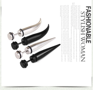 Macro shot of silver and black stainless steel spike earrings in punk style