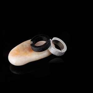Matte black and silver titanium steel clip-on hoop earrings on minimalist stone base