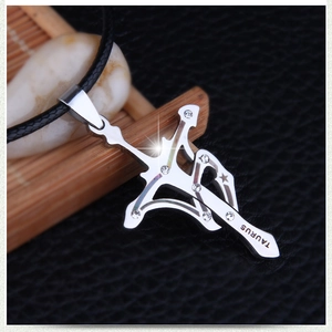 Macro detail of silver Taurus cross pendant with white zircon inlay and leather cord