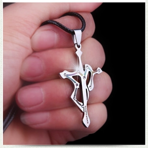 Detail of silver Sagittarius cross pendant with sparkling crystals and leather cord