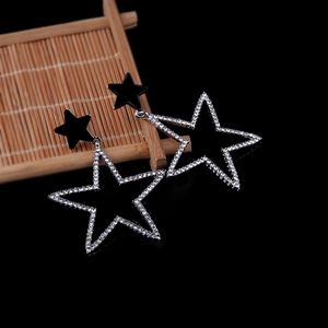 Elegant gold-plated star drop earrings with sparkling rhinestones on black background