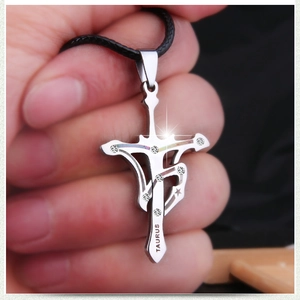 Macro shot of Taurus engraved stainless steel cross pendant with inset white crystals