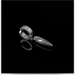 Close-up of silver bullet-shaped clip-on earring with concentric ripple texture on dark background
