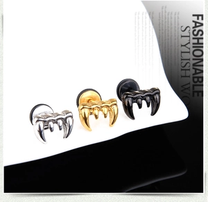 Macro shot of wolf fang stud earrings in silver, gold, and black polished finishes