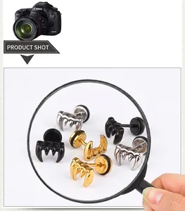 Close-up of vintage wolf tooth stud earrings in gold, silver, and black finish