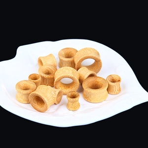 Natural bamboo hollow ear flesh tunnels and gauges set in various sizes on white plate
