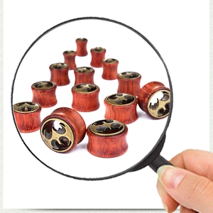 Detailaufnahme der Vintage-Fledermaus-Holzohr-Gauges mit antikem Metall-Filigranmuster