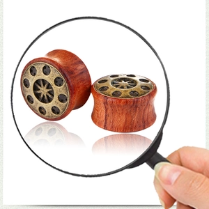 Détail macro d'écarteurs d'oreilles en bois avec motifs de relief en bronze rétro