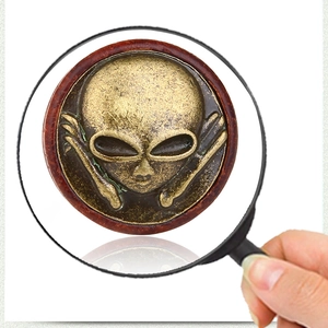 Dettaglio macro di un emblema alieno in bronzo vintage con finitura metallica