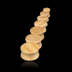 Set of natural bamboo ear plugs with saddle fit design in various sizes on black background