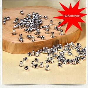 Fermoirs de boucles d'oreilles argentés en forme de balle sur support en bois naturel