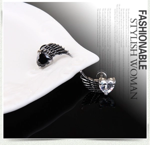 Macro shot of vintage angel wing earrings with heart-shaped zircon stones and silver finish