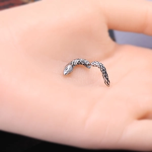 Gothic silver snake earring featuring intricate scale texture held in a hand for scale