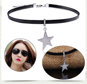 Detail of a black velvet choker with a sparkling silver star pendant and crystals