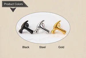 Macro detail of mini hammer stud earrings in black, steel, and gold finish