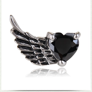 Macro shot of vintage titanium steel heart-shaped black zircon angel wing earrings detail