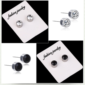 Gros plan de boucles d'oreilles en acier titane avec cristaux blancs et noirs sur carte