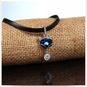 Vue macro d'un collier pendentif renard avec cristal bleu en cœur sur de la toile
