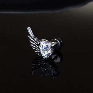 Vintage gothic wing stud earring with heart zircon stone on a black mirror background