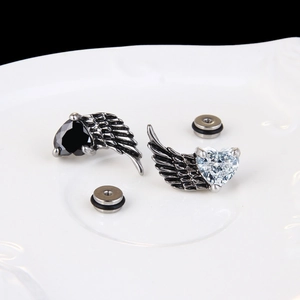 Gothic titanium steel wing earrings with heart zircon, vintage feather texture on white ceramic